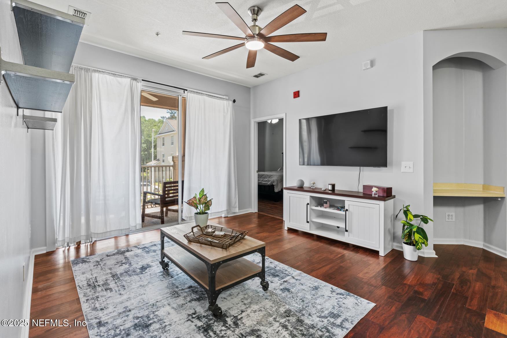 8601 Beach Boulevard, Unit 905 Jacksonville, FL 32216 - Photo 10 of 27 a living room with furniture and a flat screen tv