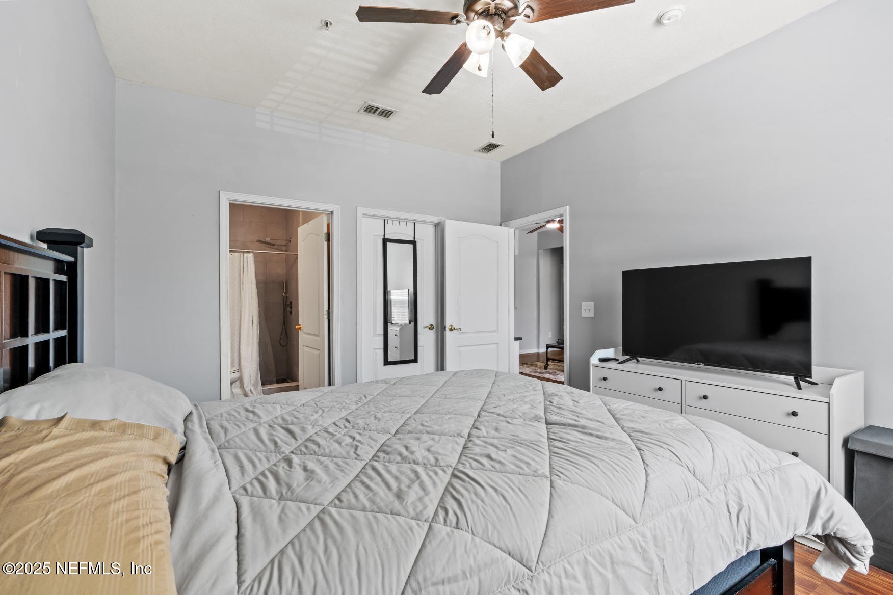 8601 Beach Boulevard, Unit 905 Jacksonville, FL 32216 - Photo 13 of 27 a bedroom with a bed and a flat tv screen on wall