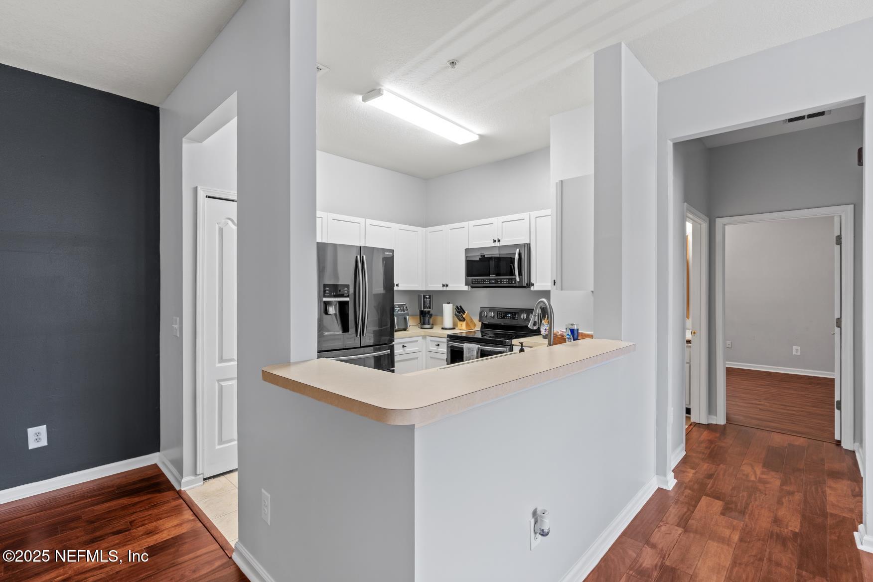 8601 Beach Boulevard, Unit 905 Jacksonville, FL 32216 - Photo 6 of 27 a kitchen view with stainless steel appliances a refrigerator and a stove top oven