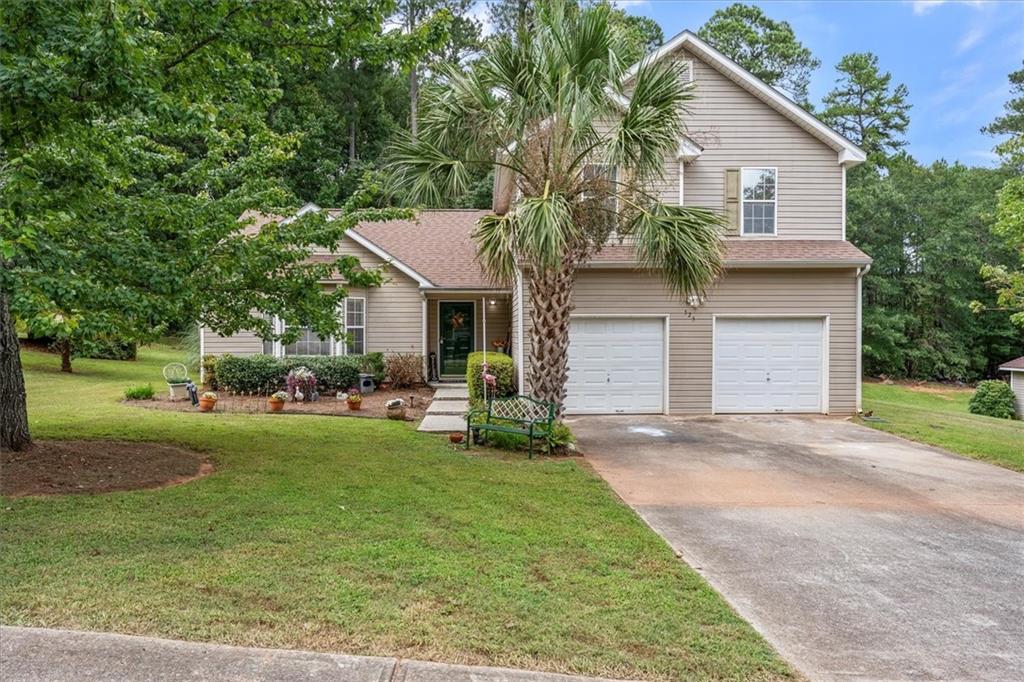 a front view of a house with a garden and trees