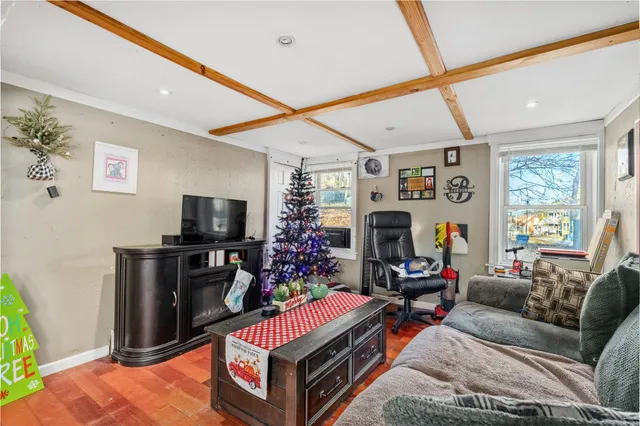 a living room with furniture a flat screen tv and a floor to ceiling window