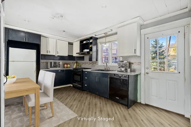 a kitchen with stainless steel appliances granite countertop a refrigerator a stove a sink dishwasher and white cabinets with wooden floor