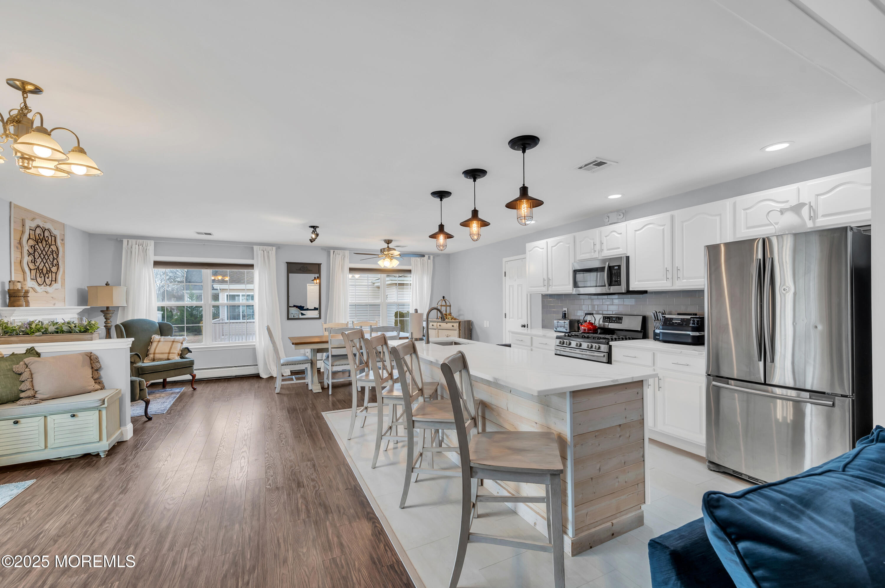 141 Cruise Road Manahawkin, NJ 08050 - Photo 8 of 37 a kitchen with stainless steel appliances granite countertop a refrigerator a stove top oven a dining table and chairs with wooden floor