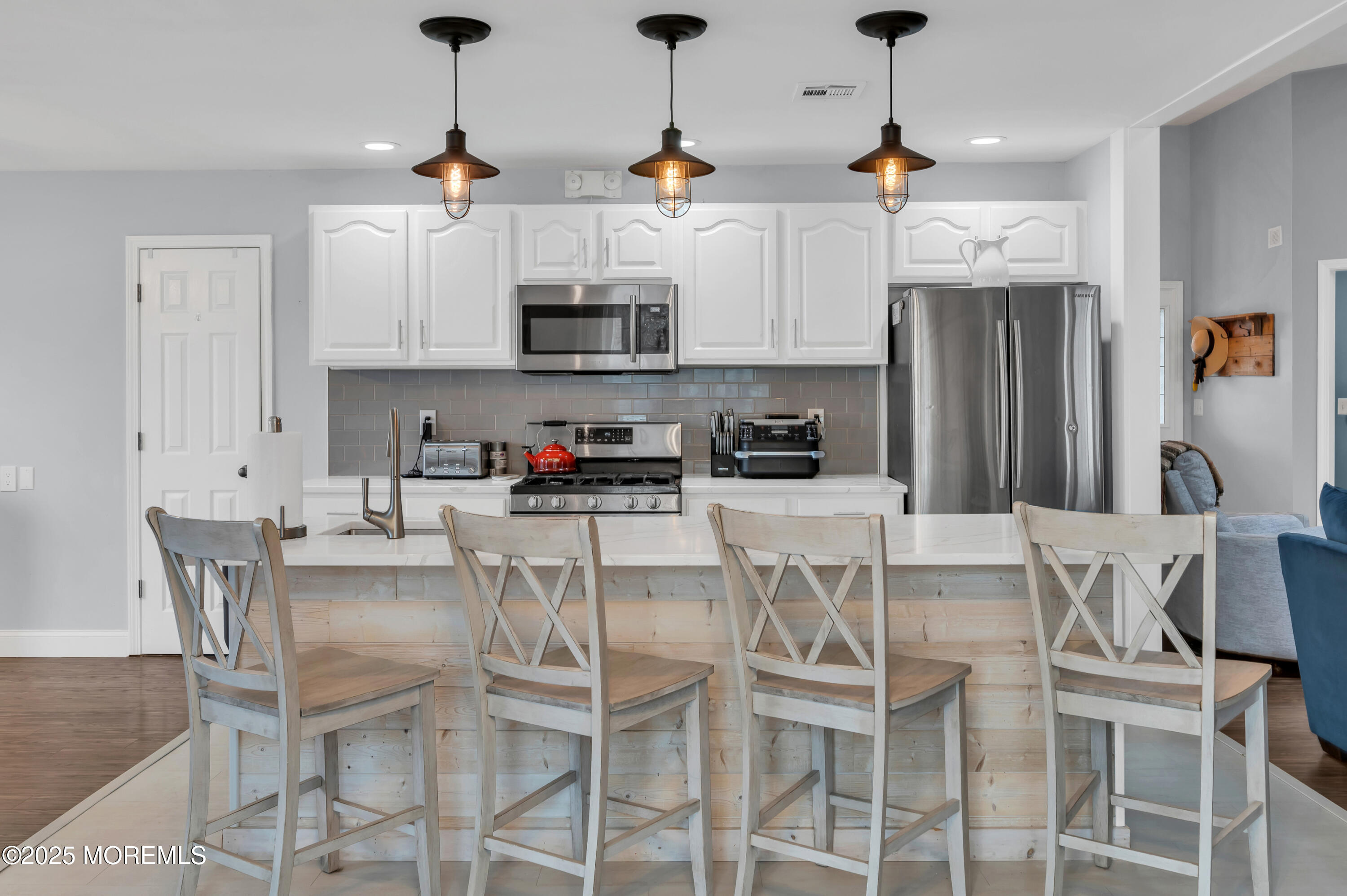 141 Cruise Road Manahawkin, NJ 08050 - Photo 9 of 37 a kitchen with stainless steel appliances kitchen island granite countertop a dining table chairs and white cabinets