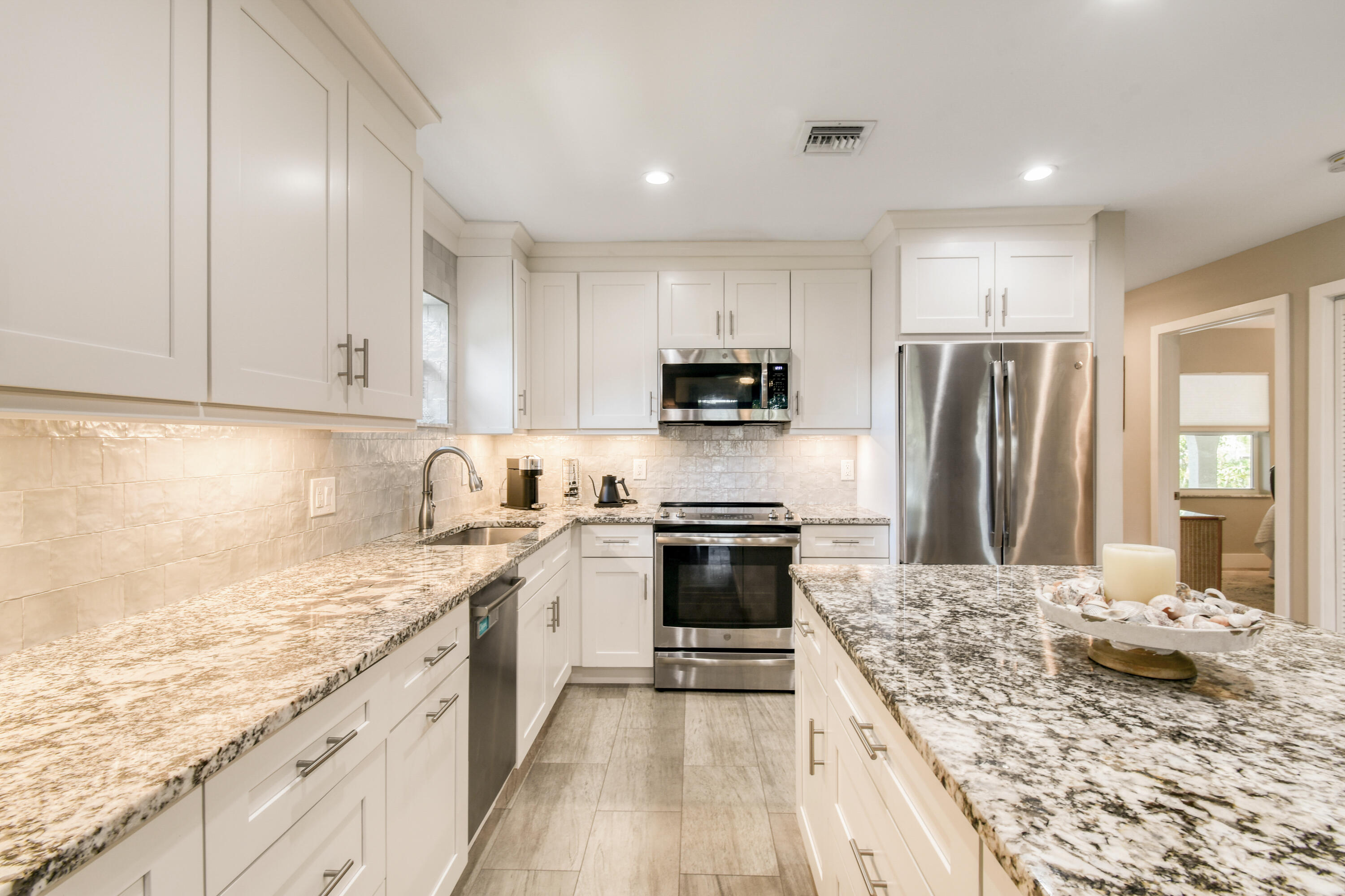 717 Highway 1, Unit 508 Jupiter, FL 33477 - Photo 13 of 66 a kitchen with kitchen island granite countertop a sink stove and refrigerator