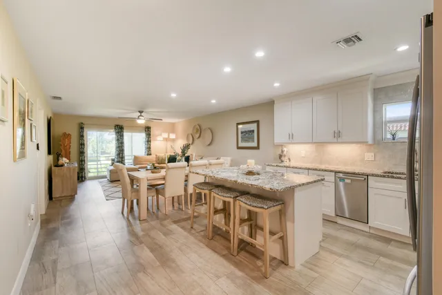 a kitchen with granite countertop a refrigerator stove microwave and sink