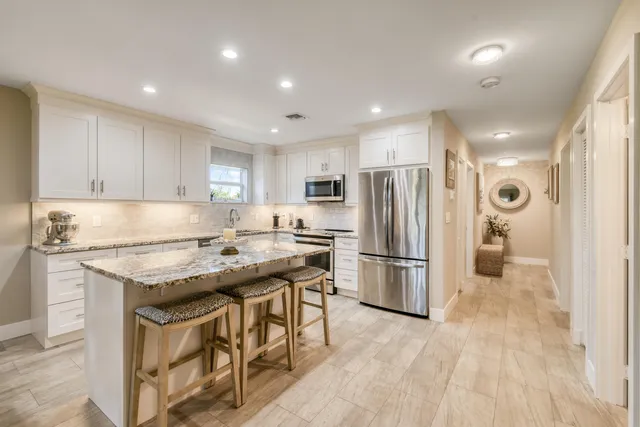 a kitchen with stainless steel appliances granite countertop a refrigerator sink and stove