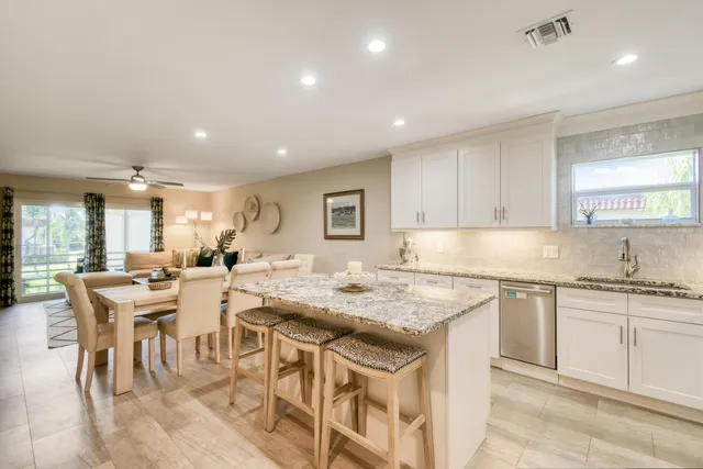 a kitchen with kitchen island granite countertop a sink stove and refrigerator