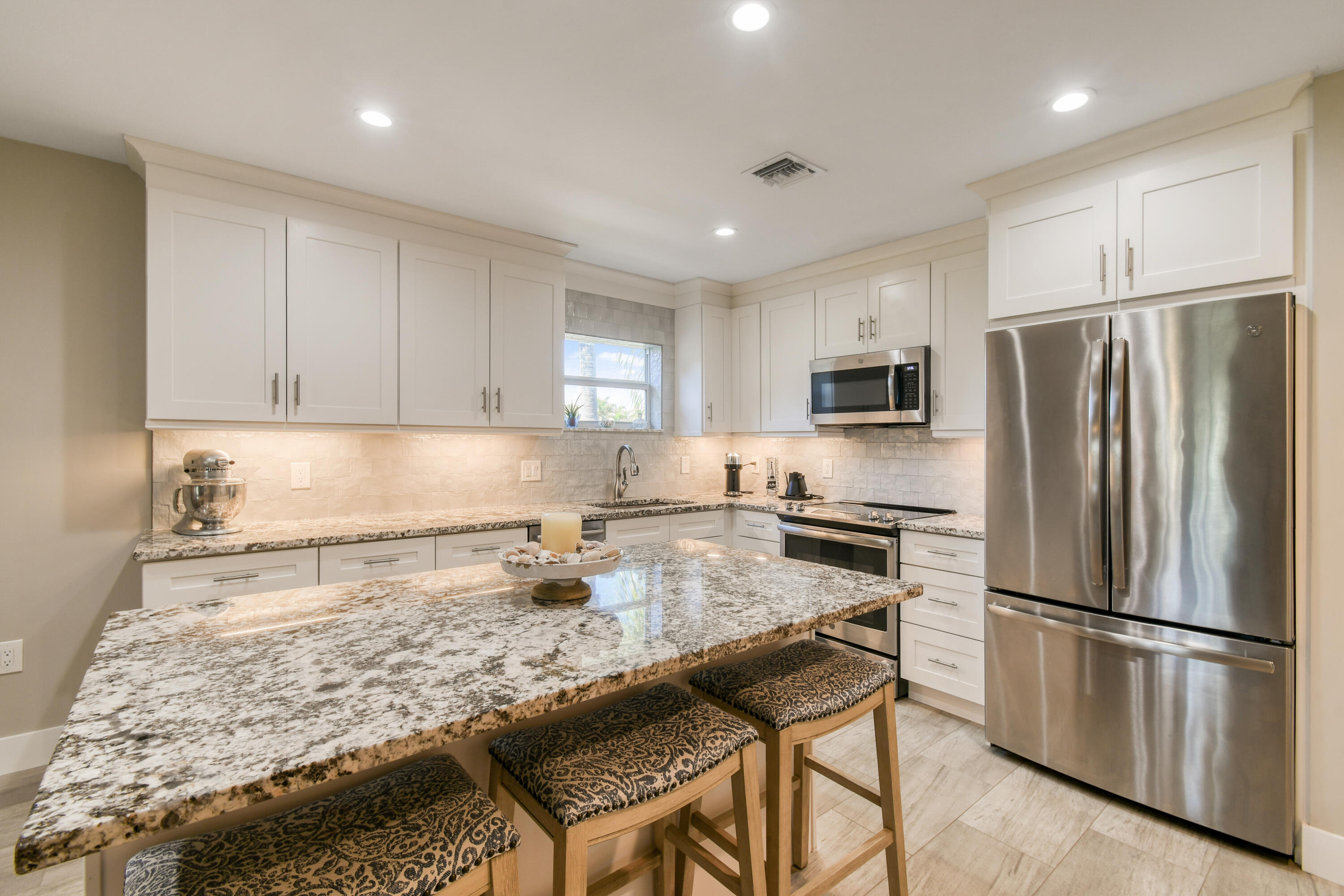 717 Highway 1, Unit 508 Jupiter, FL 33477 - Photo 10 of 66 a kitchen with granite countertop a refrigerator stove microwave and sink