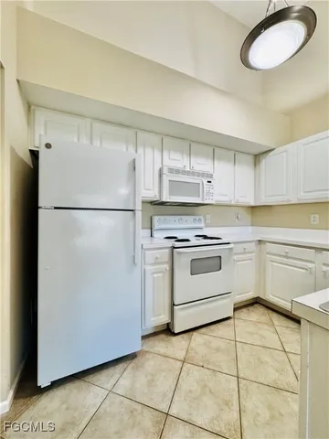a kitchen with a refrigerator sink and cabinets