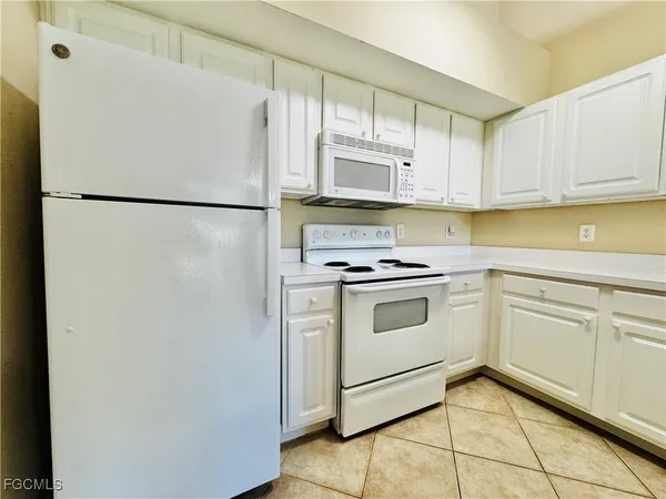 a kitchen with white cabinets and white appliances