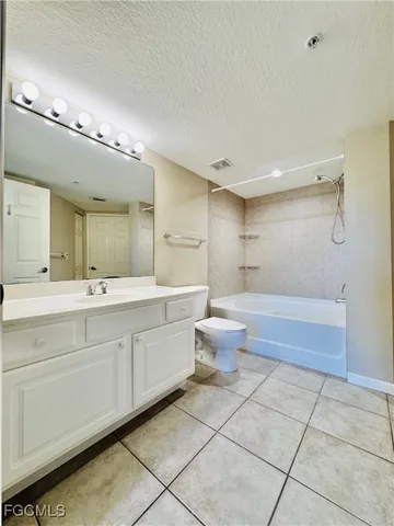 a spacious bathroom with a double vanity sink a toilet and a mirror