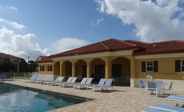a view of house with swimming pool and furniture