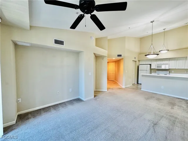 a view of an empty room with a kitchen