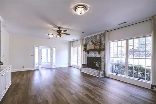 an empty room with wooden floor and chandelier fan