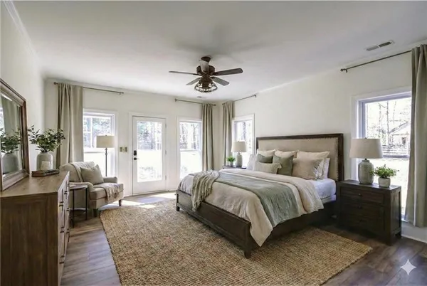 an empty room with wooden floor chandelier fan and windows