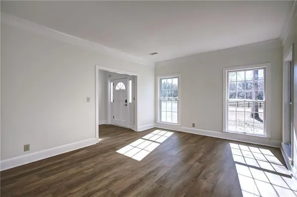 a view of a dining room with furniture a chandelier and wooden floor
