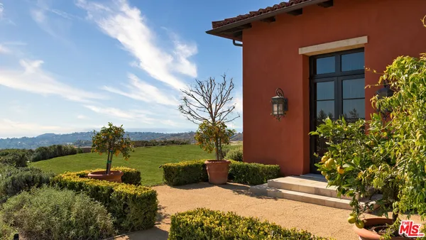 a view of a house with a yard and potted plants
