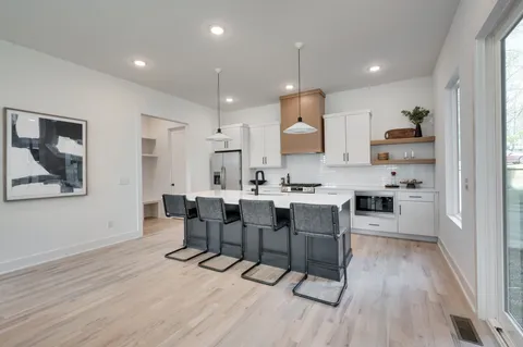a kitchen with kitchen island stainless steel appliances a sink a stove and a counter space
