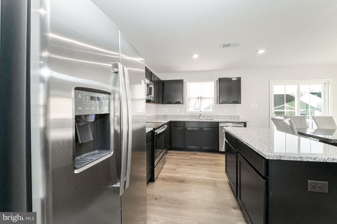 18256 Capital Court Ruther Glen, VA 22546 - Photo 11 of 26 a large kitchen with a sink and stainless steel appliances