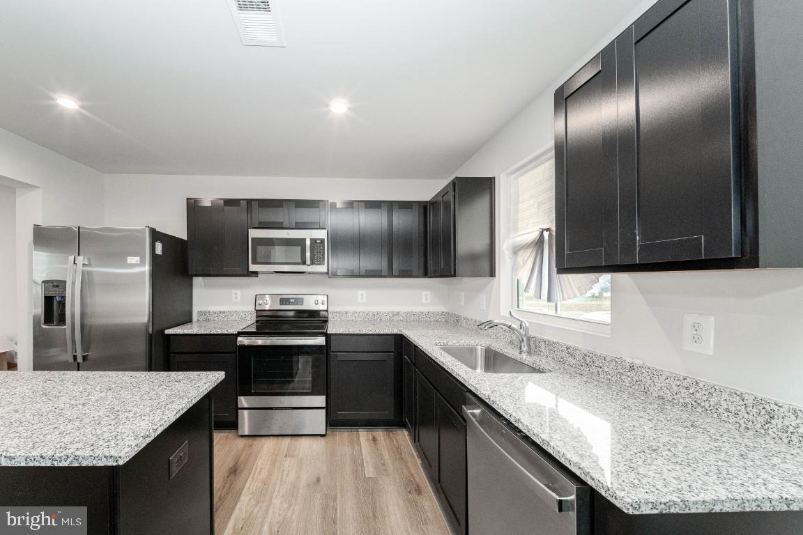 18256 Capital Court Ruther Glen, VA 22546 - Photo 12 of 26 a kitchen with stainless steel appliances granite countertop a sink stove and refrigerator