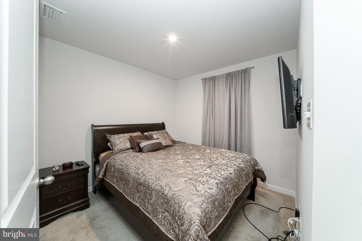 18256 Capital Court Ruther Glen, VA 22546 - Photo 19 of 26 a bedroom with a bed and wooden floor