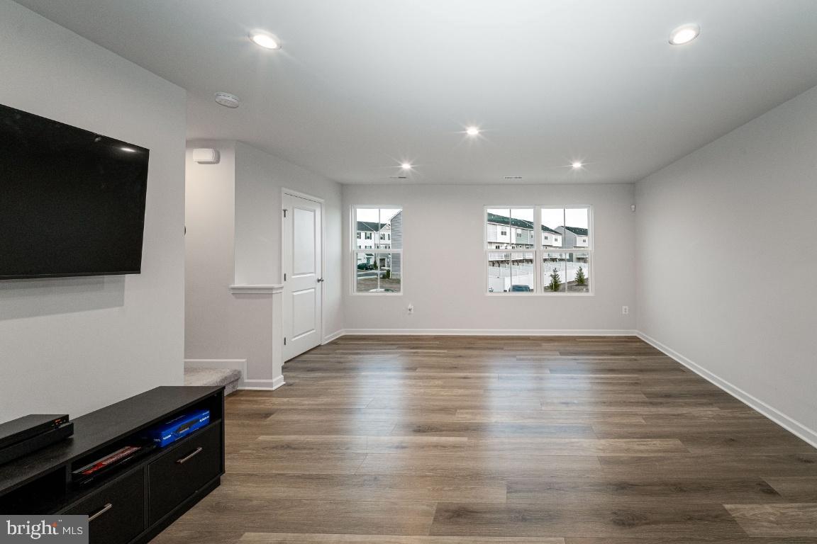 18256 Capital Court Ruther Glen, VA 22546 - Photo 9 of 26 a view of an empty room with wooden floor and a flat screen tv