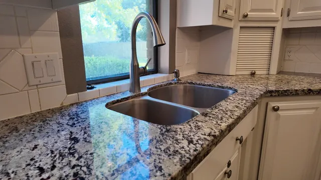 a bathroom with a granite countertop sink and a mirror