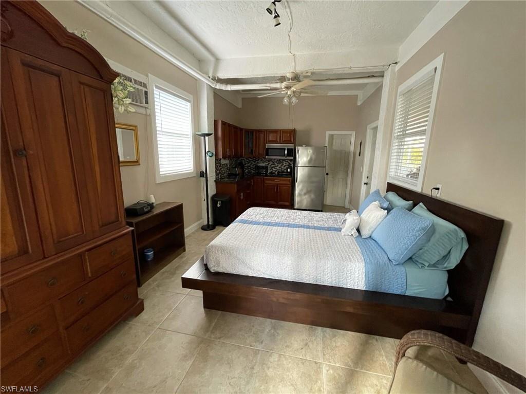 405 Cristobal Street Naples, FL 34113 - Photo 19 of 24 a large bed sitting in a living room next to a window