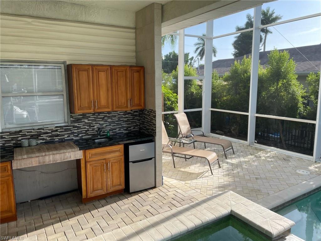 405 Cristobal Street Naples, FL 34113 - Photo 7 of 24 a kitchen with granite countertop sink stove and cabinets
