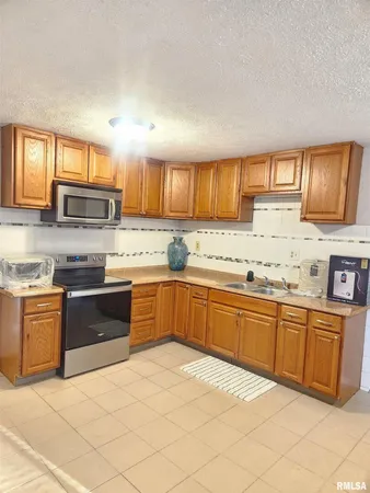 a kitchen with stainless steel appliances granite countertop a stove sink and cabinets