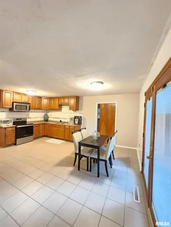 a living room with couches and kitchen view with wooden floor