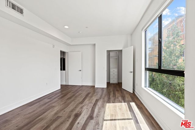 a view of hallway with a large window and wooden floor