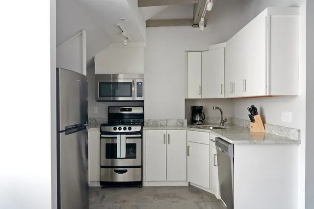 a kitchen with a sink and steel appliances