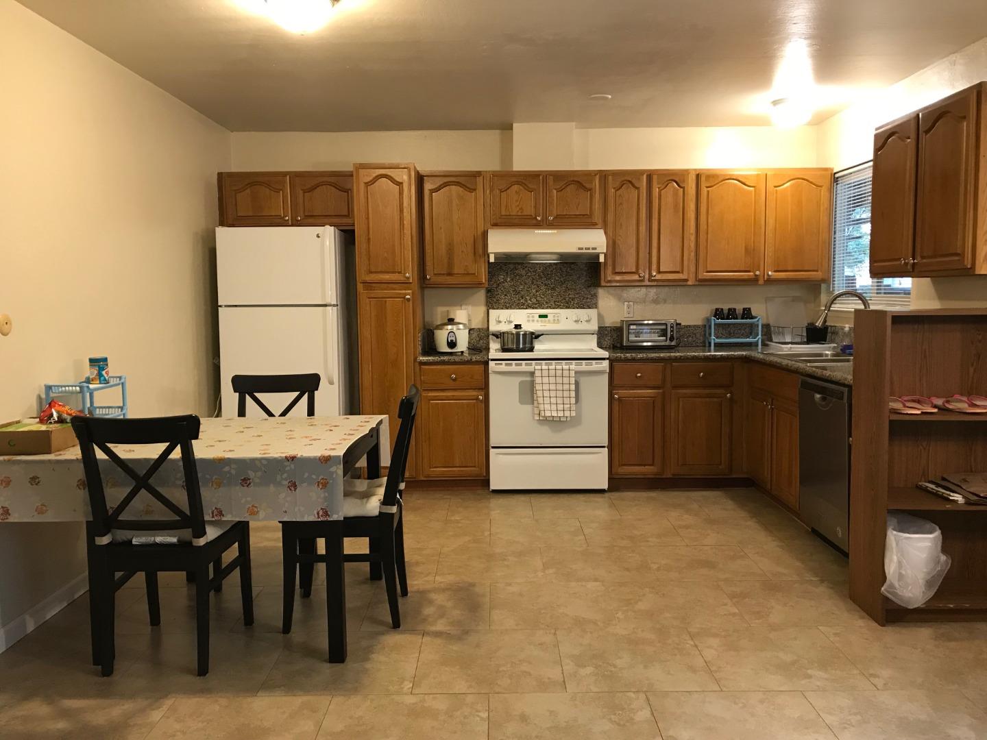 1242 Cortez Drive Sunnyvale, CA 94086 - Photo 14 of 31 a kitchen with a table chairs microwave and cabinets