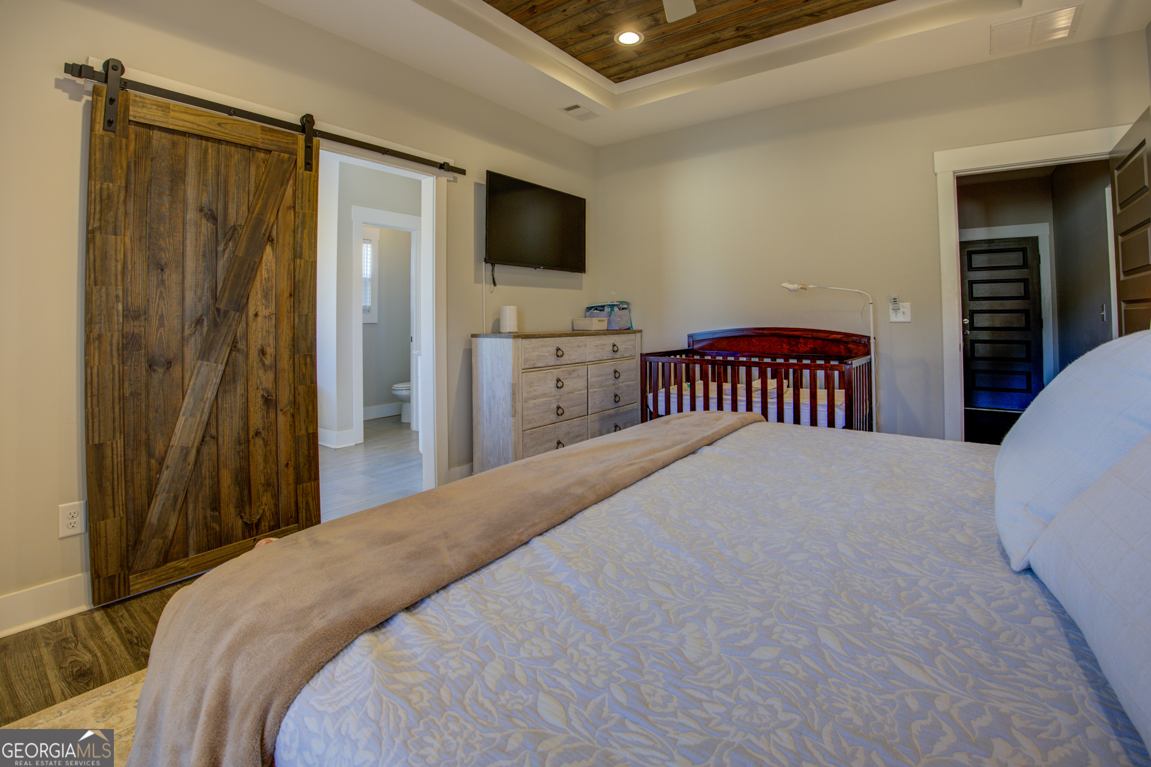 3320 Davis Academy Road Rutledge, GA 30663 - Photo 26 of 45 a bedroom with a bed and a flat tv screen on dresser