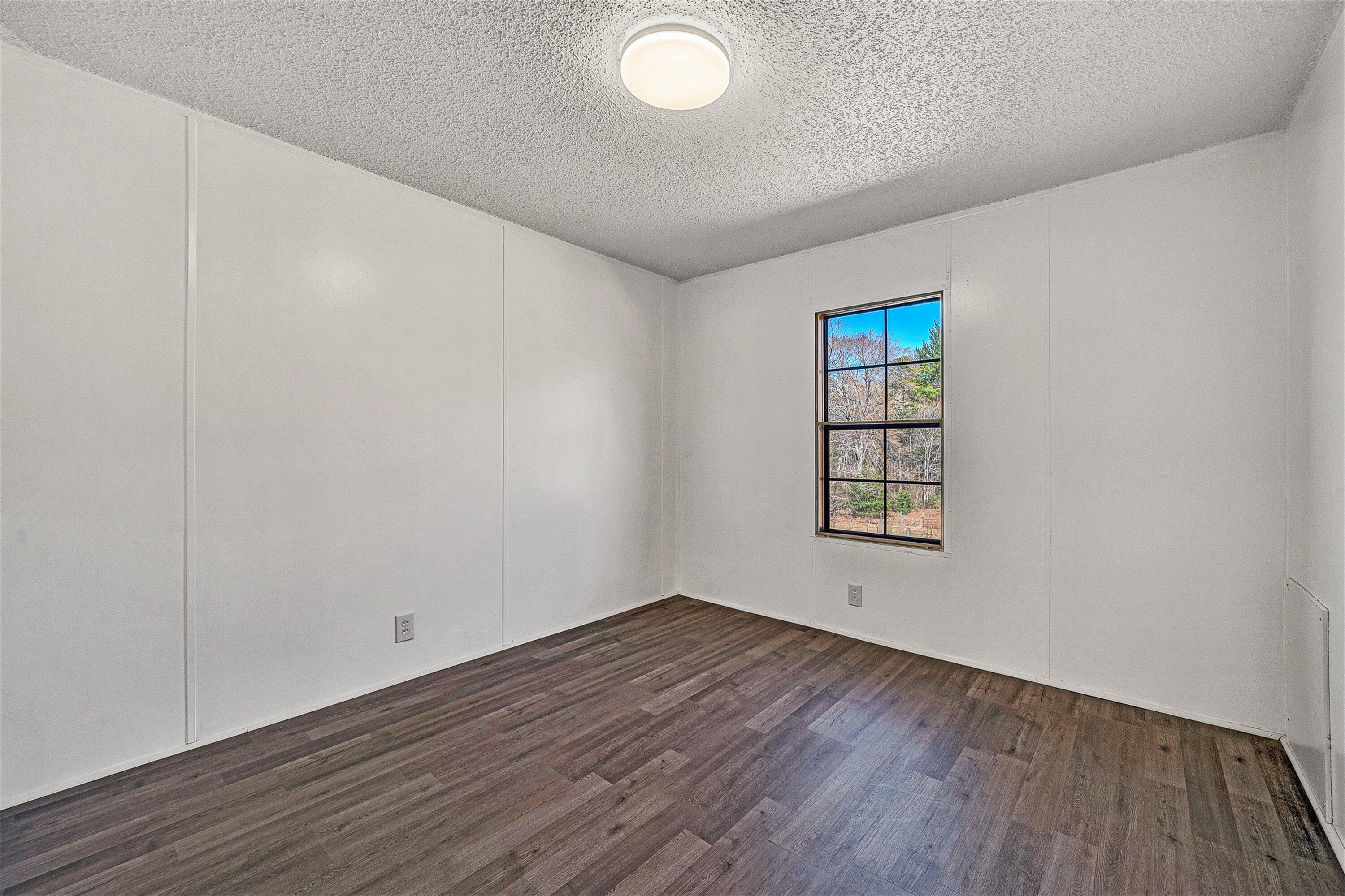 1155 Stonewall Road Blue Ridge, VA 24064 - Photo 23 of 43 an empty room with wooden floor and windows