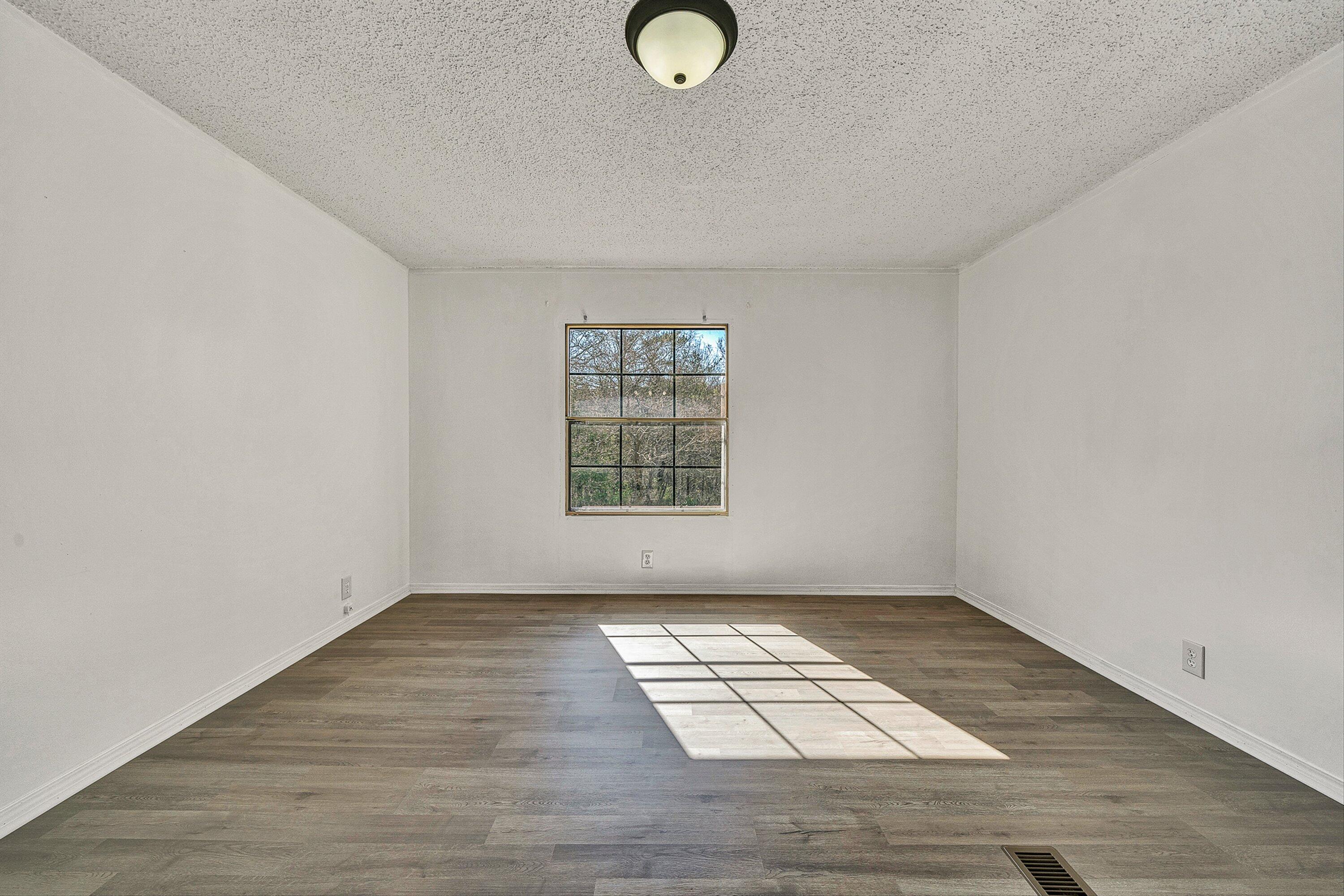 1155 Stonewall Road Blue Ridge, VA 24064 - Photo 8 of 43 an empty room with wooden floor and windows