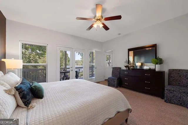 a bedroom with a bed and a flat tv screen on dresser