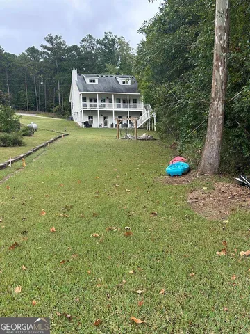 a view of a house with a yard and sitting area