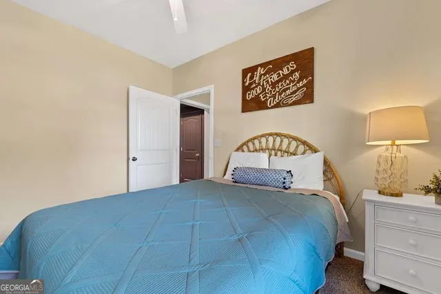 a bedroom with a bed and a lamp on dresser