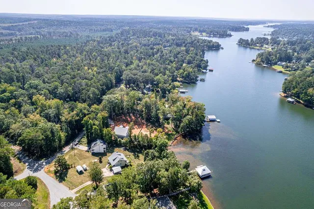 an aerial view of a house with a yard and lake view
