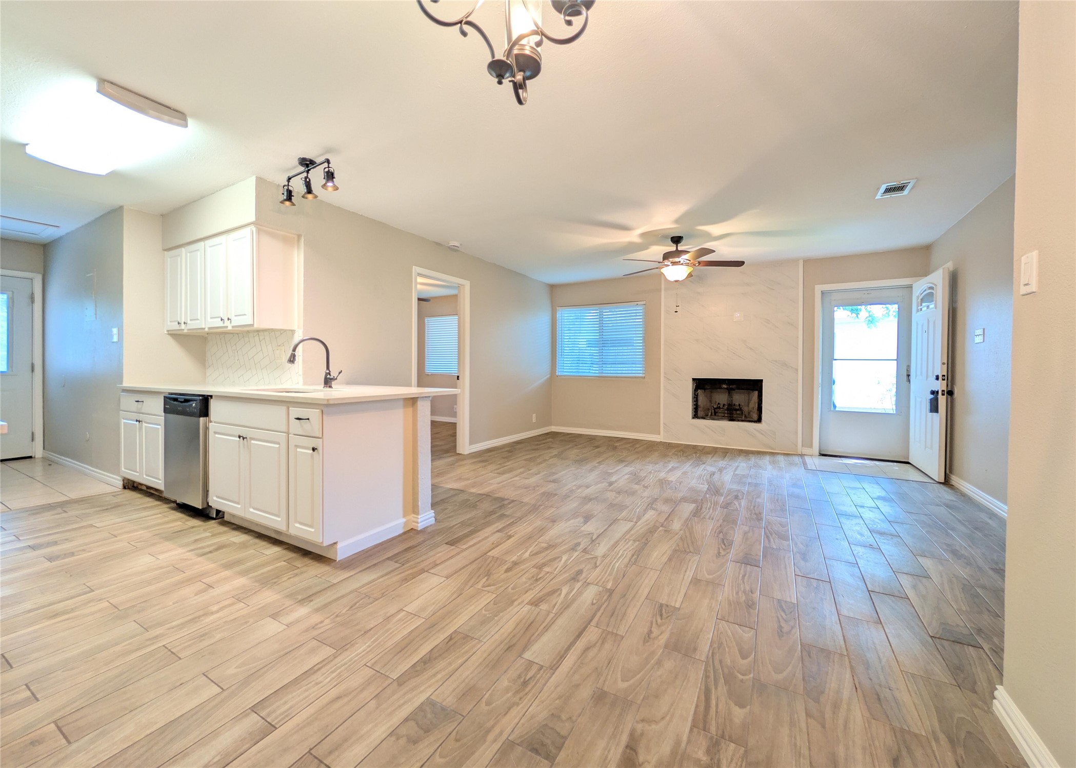12601 Turtle Rock Road, Unit B Austin, TX 78729 - Photo 20 of 20 Entry into the Living Room, Dining Room, and Kitchen open floor plan area. Fireplace next to front door.