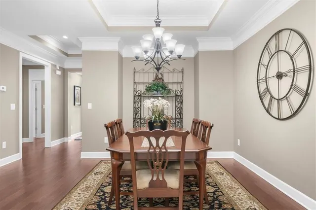 a view of a dining room with furniture a kitchen and chandelier