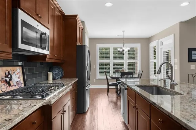 a hallway with wooden floor table and a chair