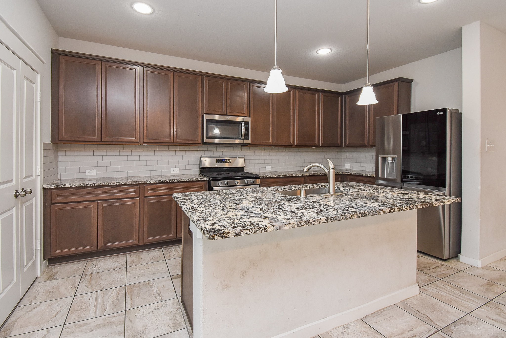 20602 Riley Copper Drive Cypress, TX 77433 - Photo 11 of 32 a kitchen with stainless steel appliances granite countertop a sink refrigerator and microwave