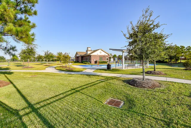 a view of a hallway with wooden floor and a bathroom