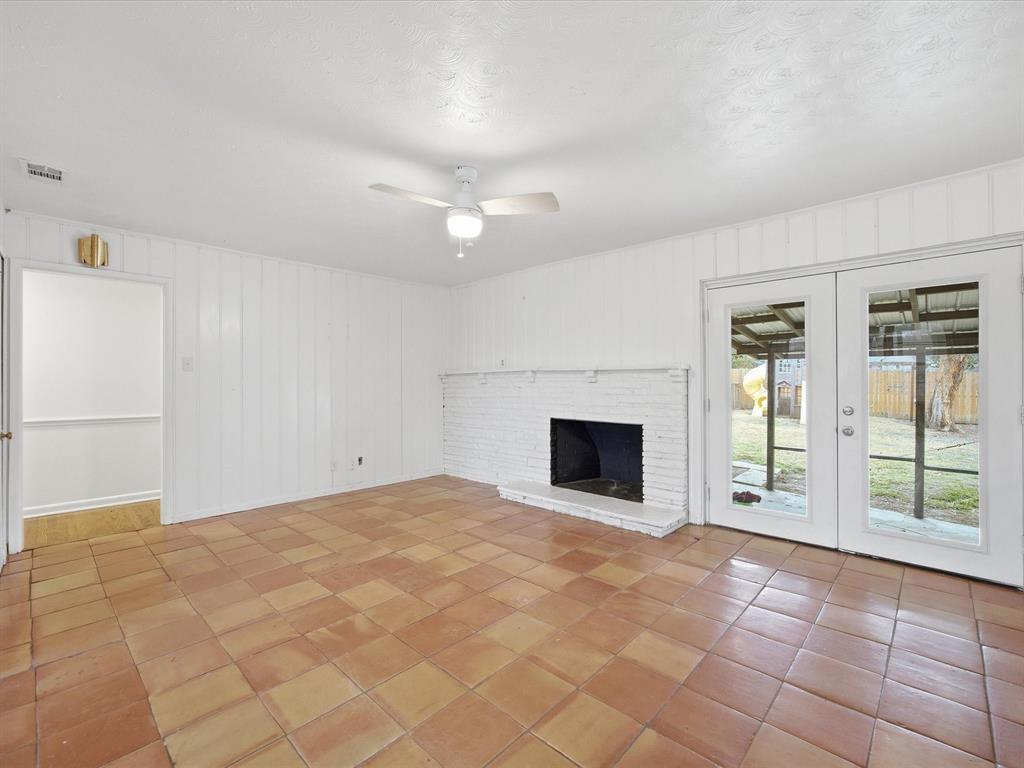 514 West Ridgewood Drive Garland, TX 75041 - Photo 15 of 39 a view of an empty room with a fireplace and a window