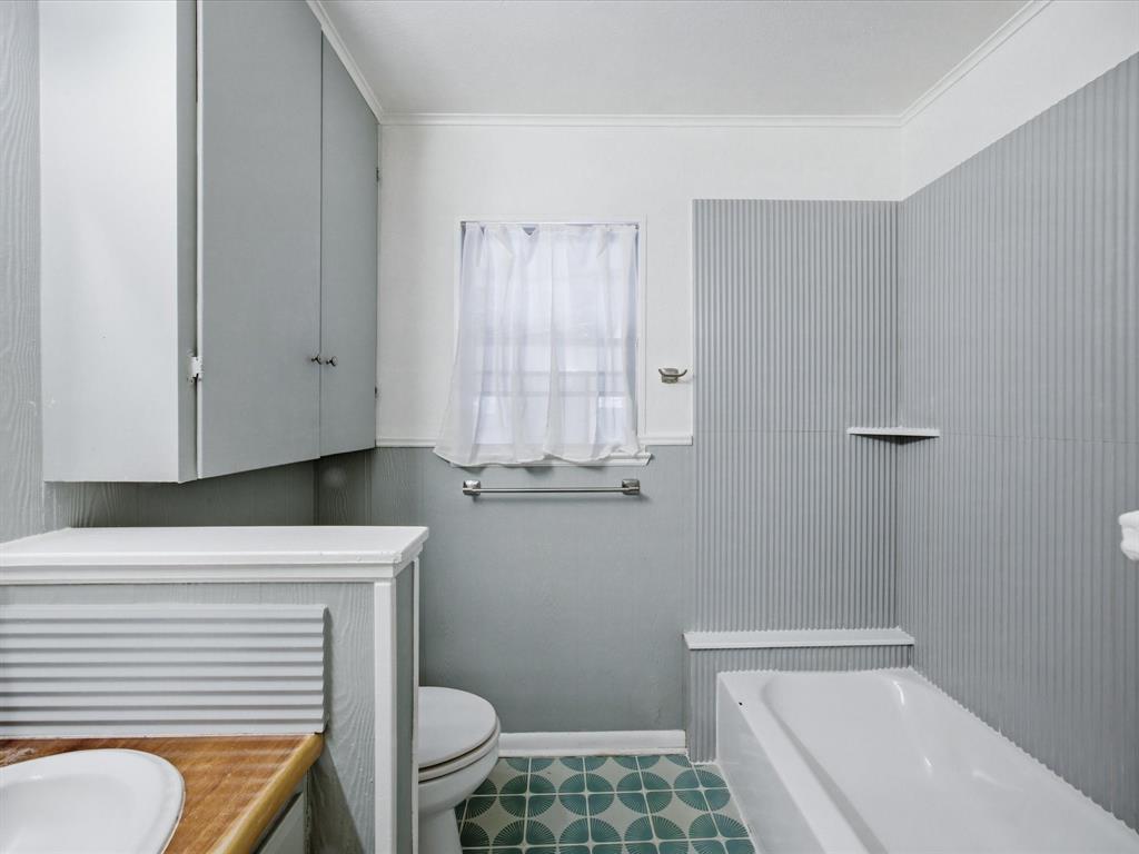 514 West Ridgewood Drive Garland, TX 75041 - Photo 24 of 39 a bathroom with a sink a toilet and a window