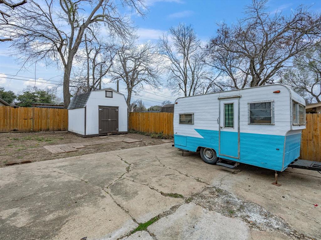 514 West Ridgewood Drive Garland, TX 75041 - Photo 27 of 39 a view of a blue house with a yard and large tree